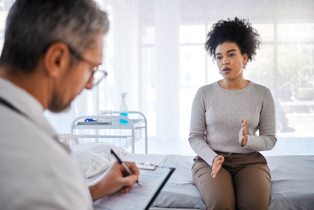 Healthcare, consulting and insurance with a black woman patient sitting in a hospital with her doctor. Medical, consultant and insurance with a female talking to a medicine professional for diagnosis.